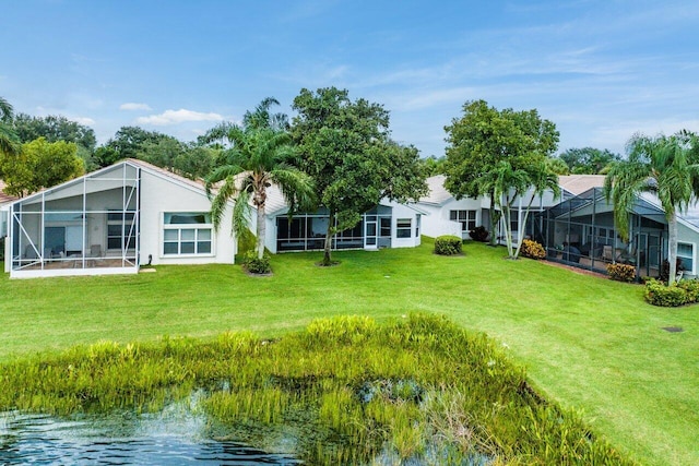 view of yard with glass enclosure and a water view