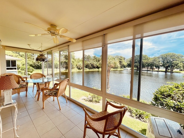 sunroom featuring ceiling fan and a water view