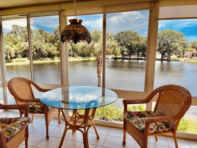 sunroom featuring a water view