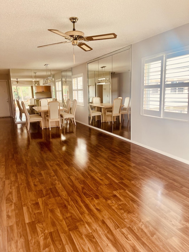 dining space with hardwood / wood-style floors, ceiling fan, and a textured ceiling