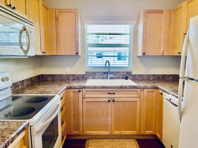 kitchen featuring light brown cabinetry, white appliances, and sink