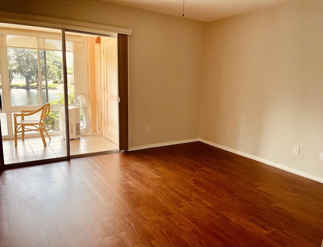 spare room featuring hardwood / wood-style floors and a water view