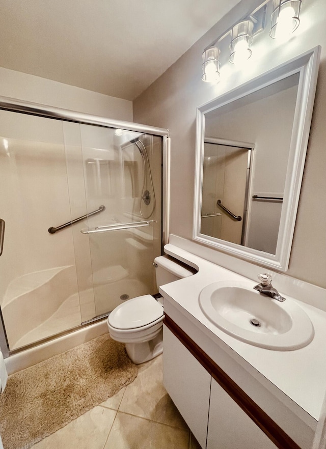 bathroom with tile patterned flooring, vanity, toilet, and an enclosed shower