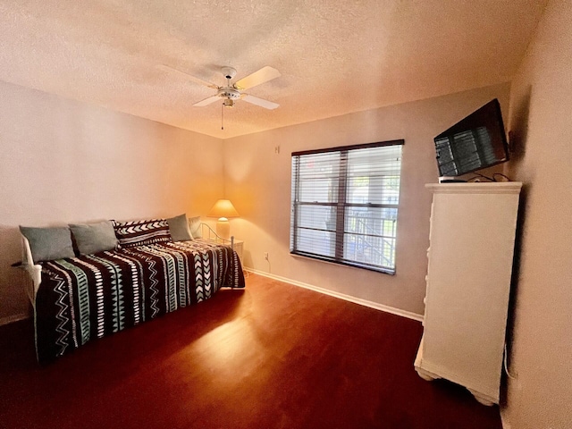 bedroom with ceiling fan, a textured ceiling, and hardwood / wood-style flooring