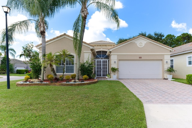 mediterranean / spanish-style home with stucco siding, a front lawn, decorative driveway, and a garage