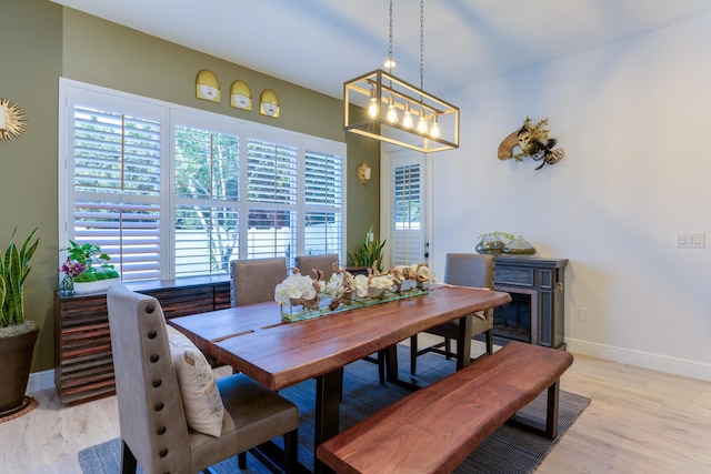 dining area featuring light wood-style flooring and baseboards