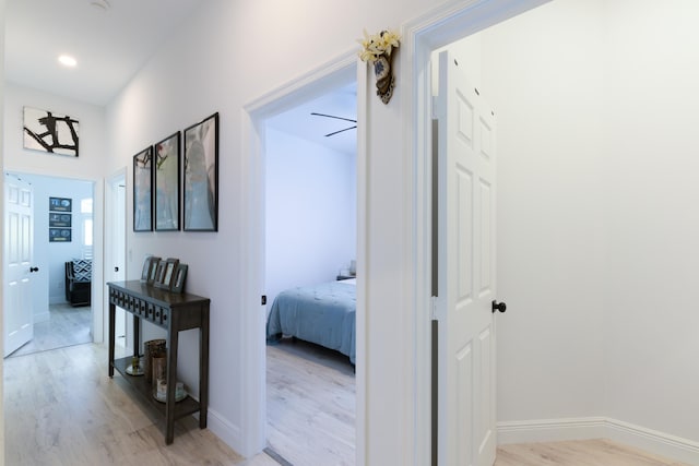 hall with baseboards and light wood-style floors