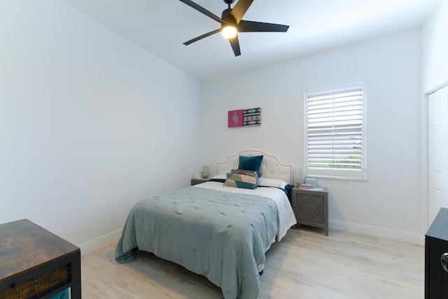 bedroom with baseboards, a ceiling fan, and light wood finished floors