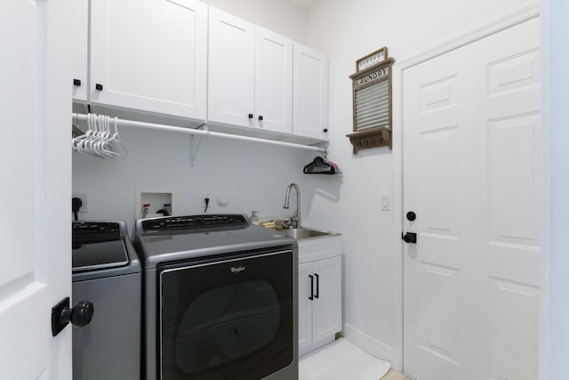 clothes washing area with a sink, baseboards, cabinet space, and washing machine and clothes dryer