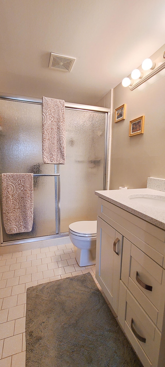 bathroom with vanity, toilet, walk in shower, and tile patterned floors