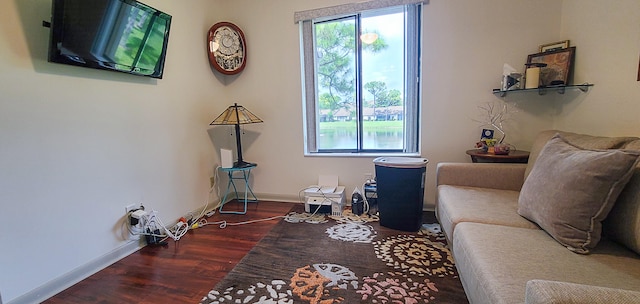 sitting room with plenty of natural light and dark wood-type flooring