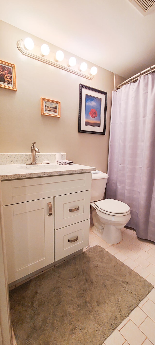 bathroom with vanity, toilet, a shower with shower curtain, and tile patterned flooring