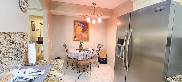 dining area featuring ornamental molding and light tile patterned flooring