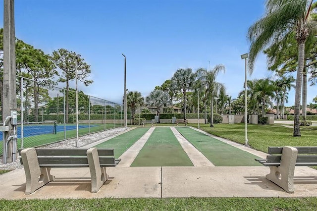 view of community with a yard and tennis court