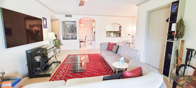 living room featuring ceiling fan, light tile patterned floors, and ornamental molding