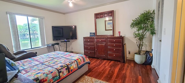 bedroom with dark wood finished floors and crown molding