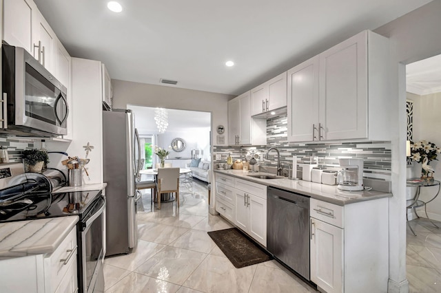 kitchen featuring sink, appliances with stainless steel finishes, white cabinetry, and decorative backsplash