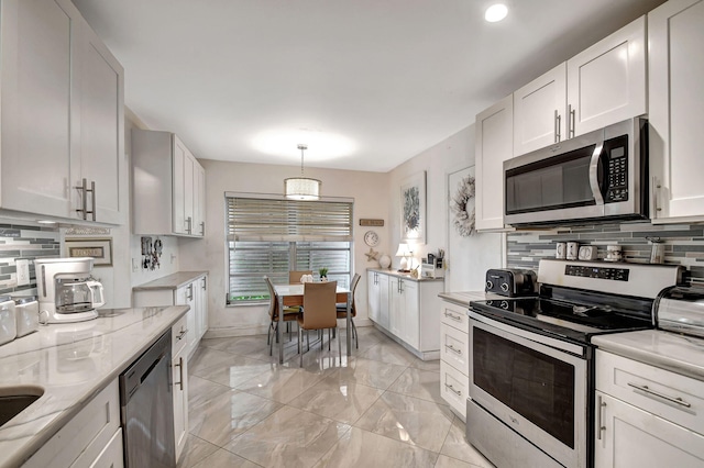 kitchen featuring decorative light fixtures, backsplash, appliances with stainless steel finishes, light stone counters, and white cabinets