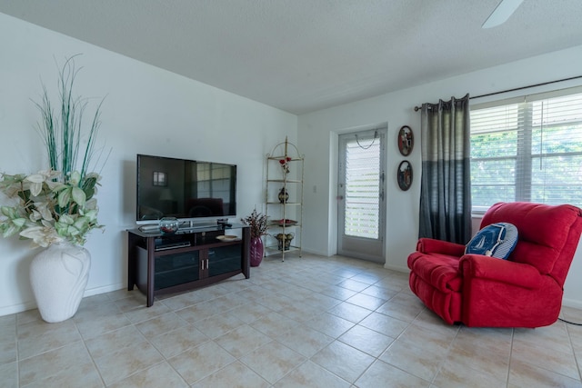 tiled living room featuring a textured ceiling and ceiling fan