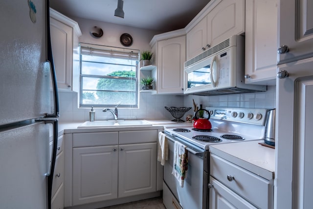 kitchen with white cabinetry, white appliances, sink, and decorative backsplash