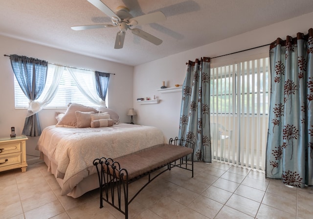 bedroom with ceiling fan, light tile patterned floors, access to outside, and a textured ceiling