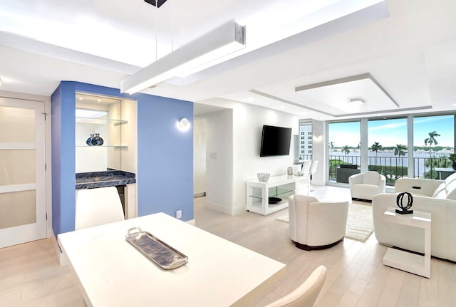 dining area featuring a wall of windows and light hardwood / wood-style flooring