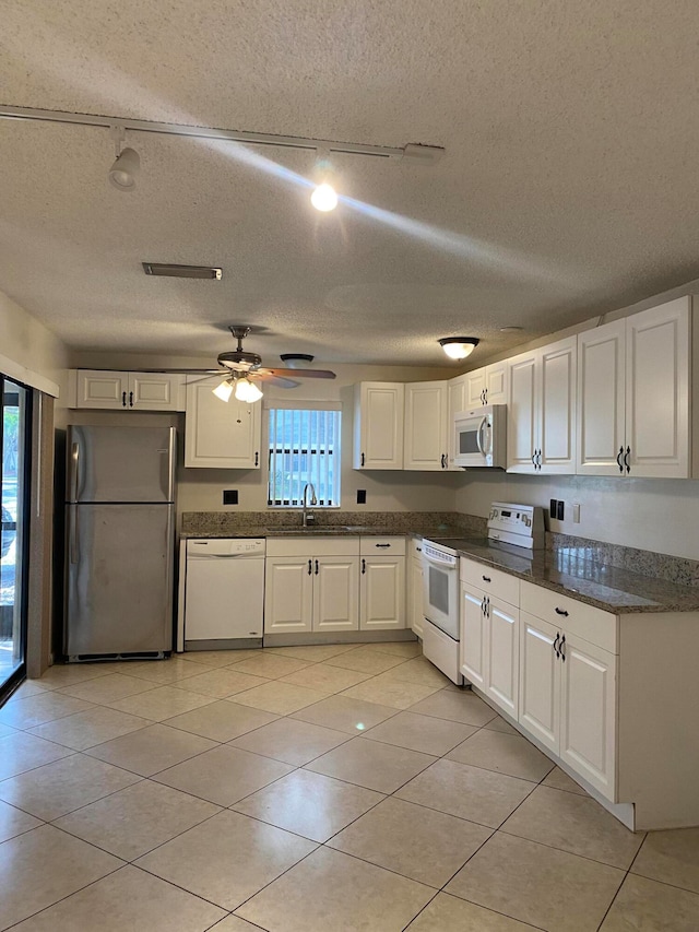 kitchen with a wealth of natural light, ceiling fan, white appliances, and white cabinets