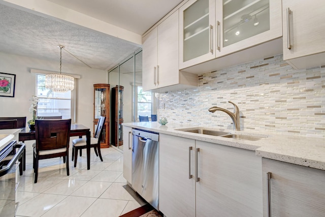 kitchen featuring light stone countertops, appliances with stainless steel finishes, sink, hanging light fixtures, and light tile patterned flooring