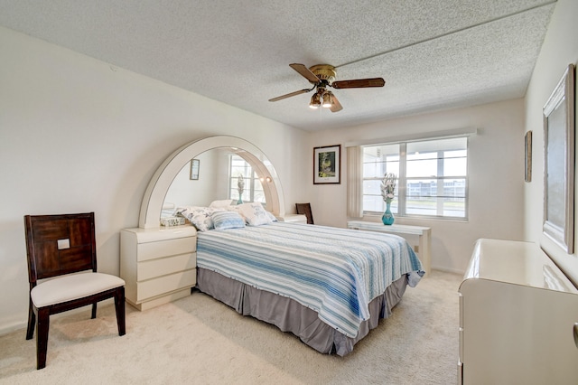 carpeted bedroom with a textured ceiling and ceiling fan