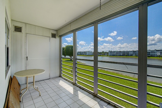 sunroom / solarium featuring a water view