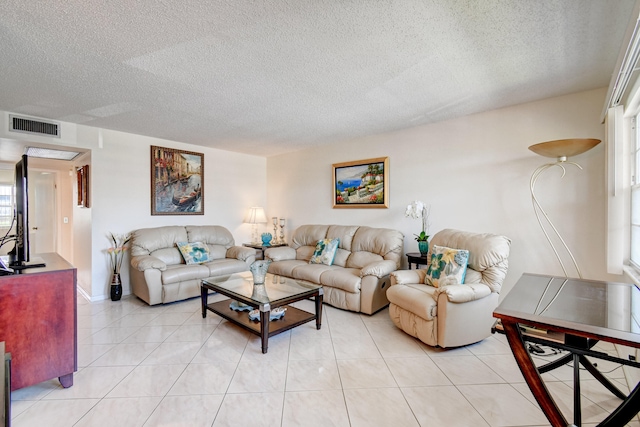 living room featuring light tile patterned floors, a healthy amount of sunlight, and a textured ceiling