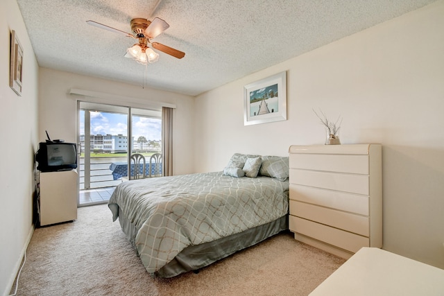 bedroom featuring access to exterior, ceiling fan, light colored carpet, and a textured ceiling