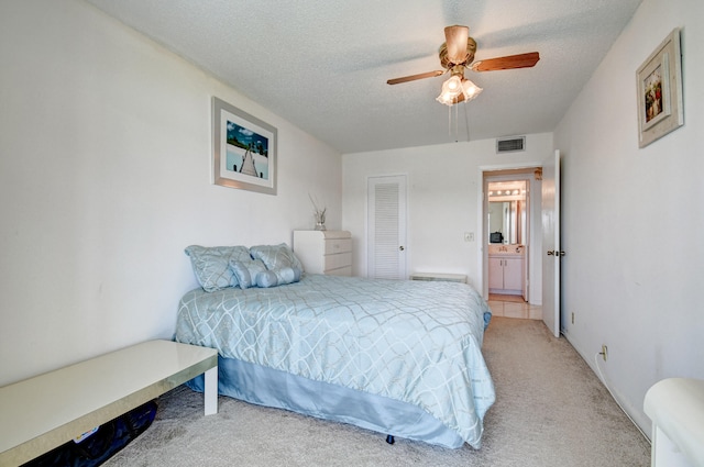 carpeted bedroom featuring a textured ceiling, ceiling fan, and connected bathroom