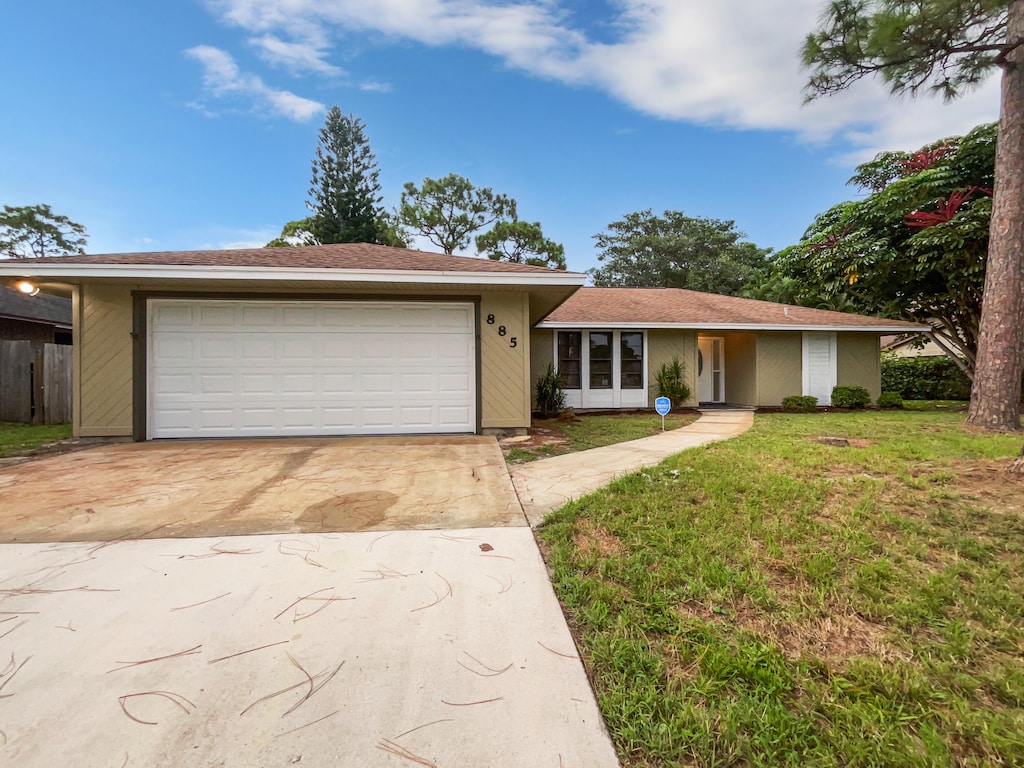 ranch-style house with a garage and a front yard