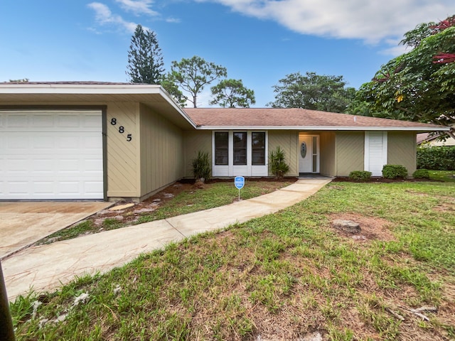 ranch-style house featuring a garage and a front lawn