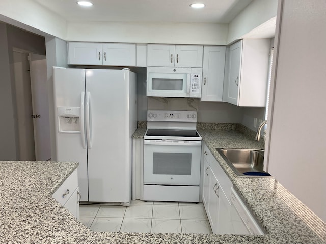 kitchen featuring white appliances, sink, light stone counters, and white cabinets