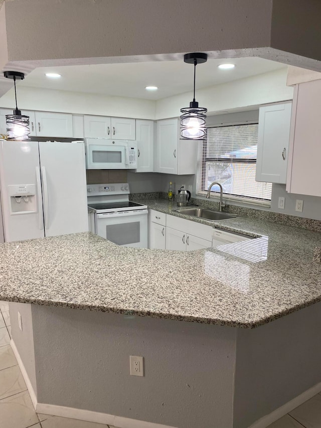 kitchen with pendant lighting, white cabinets, sink, and white appliances