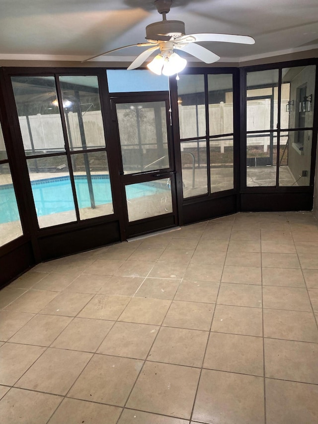 unfurnished sunroom with ceiling fan