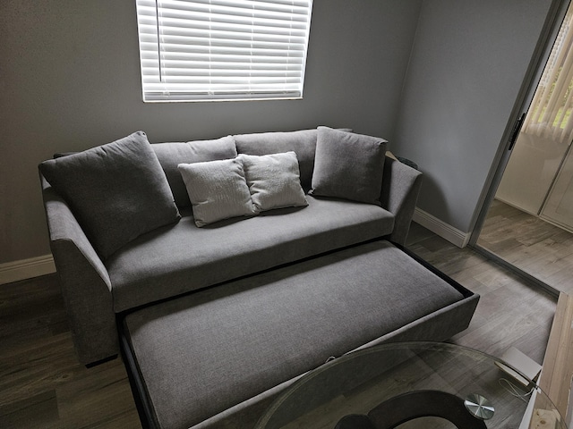 living area with baseboards and wood finished floors