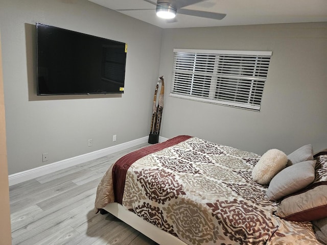 bedroom featuring a ceiling fan, baseboards, and wood finished floors