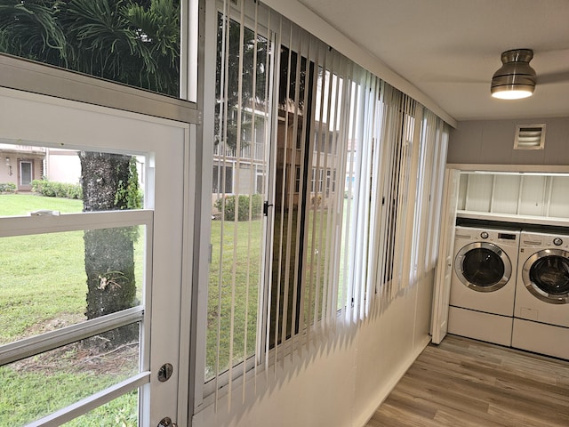 laundry room featuring wood finished floors, visible vents, and separate washer and dryer