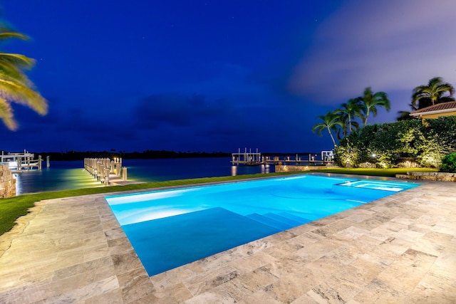 pool at twilight with a water view and a patio