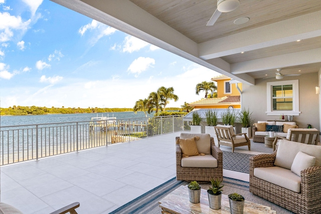 view of patio with an outdoor living space, a water view, and ceiling fan