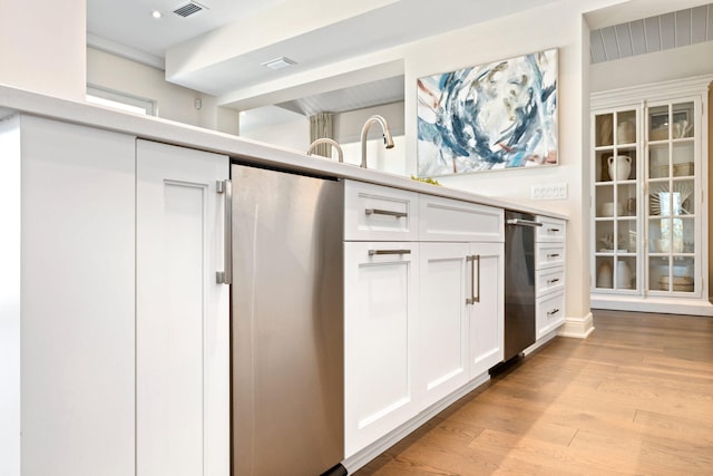 kitchen with white cabinetry and light hardwood / wood-style flooring