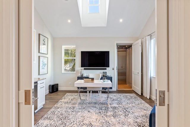 home office featuring hardwood / wood-style floors and lofted ceiling with skylight