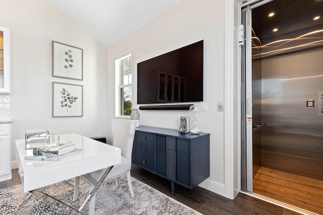 office area featuring lofted ceiling, elevator, and dark hardwood / wood-style flooring