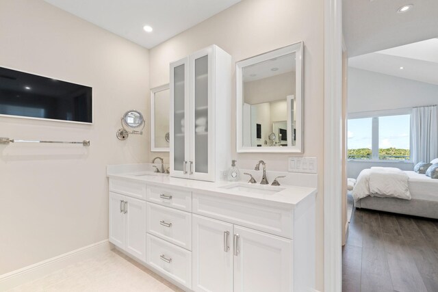 bathroom featuring vanity, lofted ceiling, and wood-type flooring