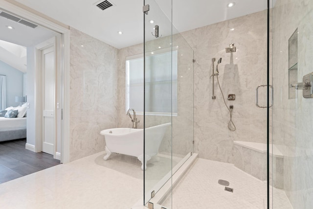 bathroom with wood-type flooring and shower with separate bathtub