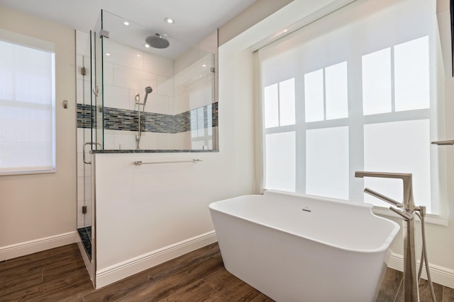 bathroom with wood-type flooring and plus walk in shower