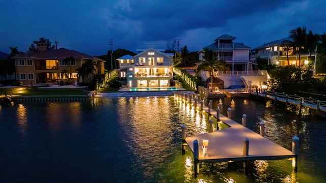 view of dock featuring a water view, a patio area, and a balcony